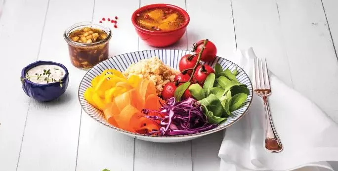Salada Colorida com Trio de Molhos em um prato fundo. Ao redor, vemos mais três tigelas com molhos diferentes.