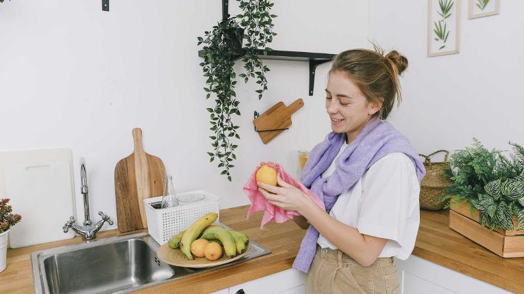 Alimentos naturais e orgânicos: mulher limpando uma fruta