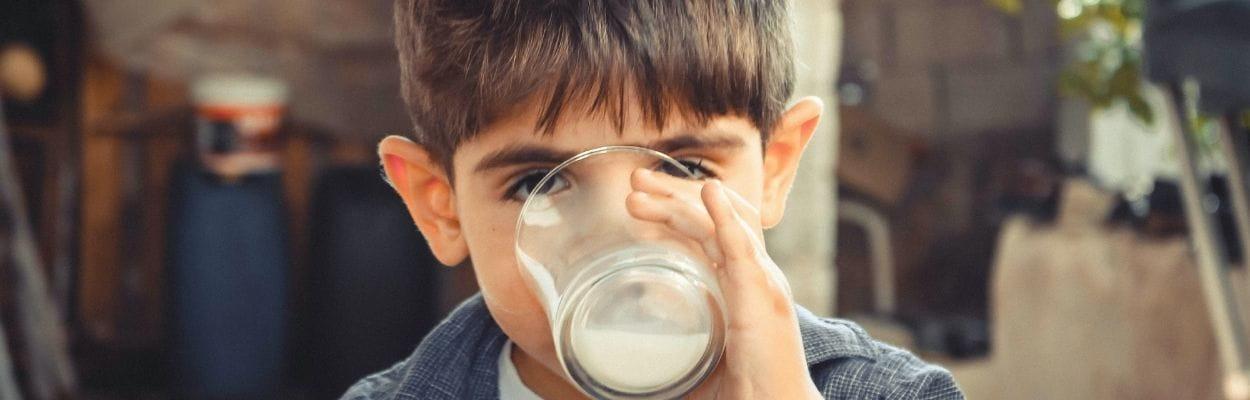 Diferença entre alergia e intolerância: menino tomando leite
